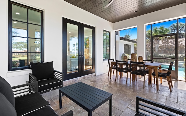 sunroom / solarium featuring wood ceiling and french doors