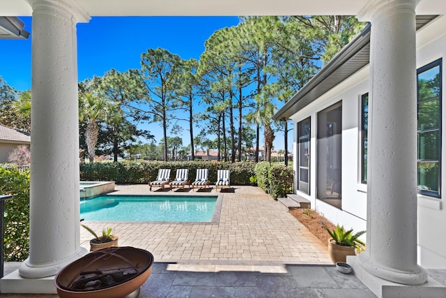 view of swimming pool with a patio, fence, and a pool with connected hot tub