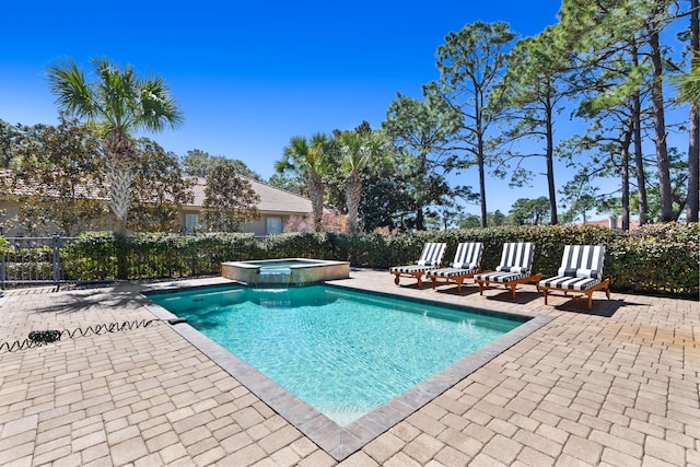 view of pool with a pool with connected hot tub, a patio, and fence