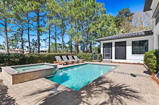 view of swimming pool featuring a pool with connected hot tub, a patio area, and a sunroom