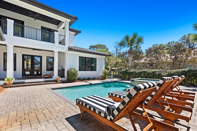 view of swimming pool featuring a patio, french doors, a pool with connected hot tub, and ceiling fan