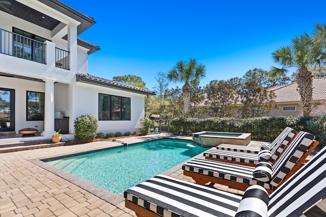 view of pool featuring a patio and a pool with connected hot tub