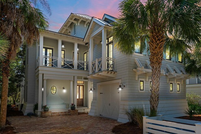 view of front facade featuring a garage, decorative driveway, and a balcony