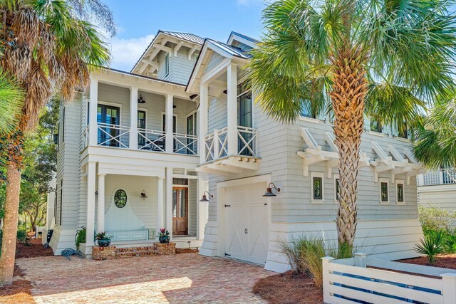 view of front of house with decorative driveway, a balcony, and an attached garage