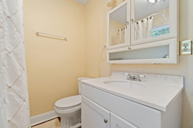 full bathroom featuring vanity, toilet, and baseboards