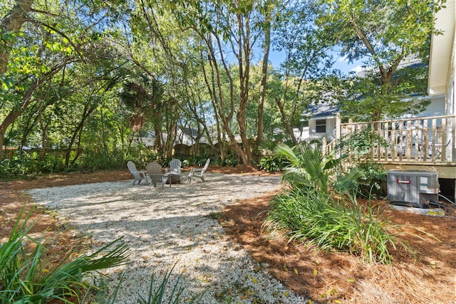 view of yard featuring an outdoor fire pit and central AC