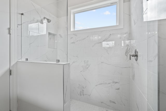 bathroom featuring a marble finish shower