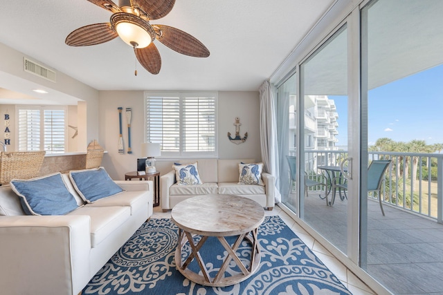 living area with tile patterned flooring, visible vents, and ceiling fan