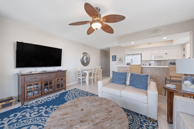 living room with a ceiling fan, visible vents, baseboards, and light tile patterned floors