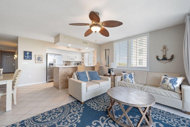 living room featuring visible vents, ceiling fan, baseboards, and light tile patterned floors