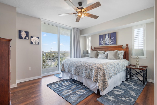 bedroom featuring baseboards, ceiling fan, wood finished floors, access to outside, and expansive windows