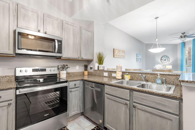 kitchen with ceiling fan, light tile patterned floors, a peninsula, a sink, and appliances with stainless steel finishes