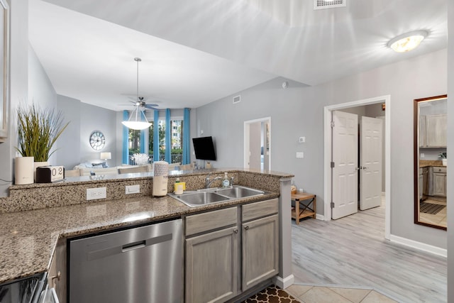 kitchen with stainless steel dishwasher, stone countertops, a sink, and pendant lighting