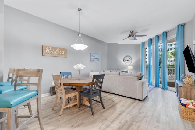 dining space with light wood-style floors, ceiling fan, and baseboards