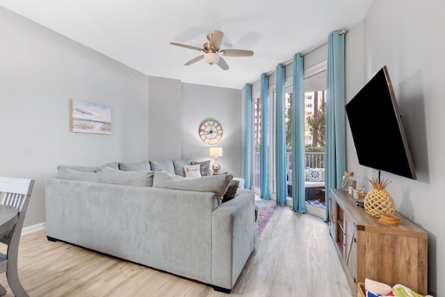 living area with light wood finished floors, ceiling fan, and baseboards