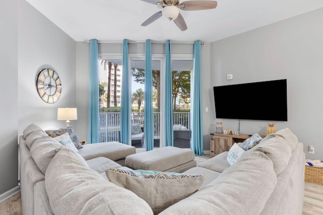 living room with baseboards, a ceiling fan, and wood finished floors