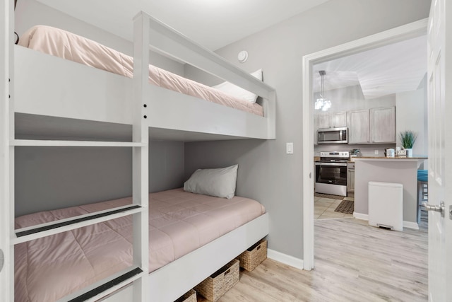 bedroom with baseboards and light wood finished floors