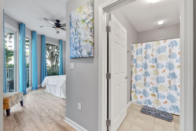 bathroom with curtained shower, ceiling fan, baseboards, and ensuite bathroom