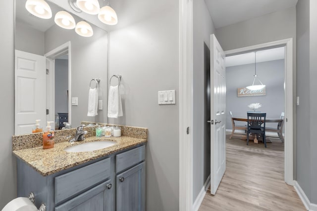 bathroom with baseboards, wood finished floors, and vanity