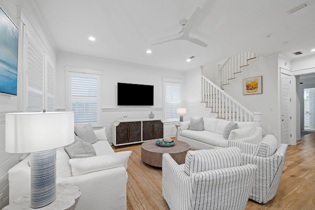 living room with ornamental molding, light wood-type flooring, and a wealth of natural light