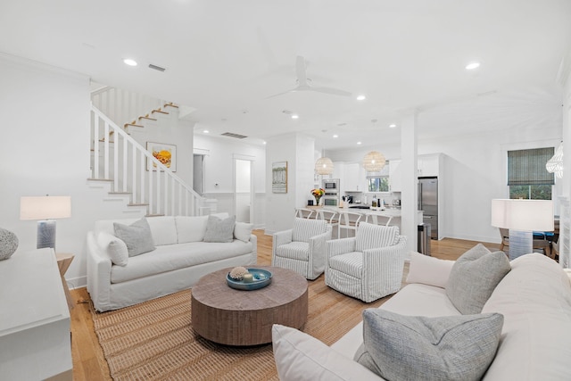 living room with visible vents, stairway, light wood-style flooring, and recessed lighting