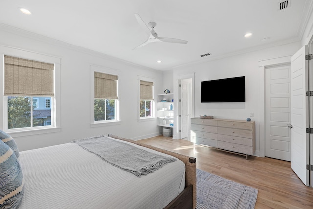 bedroom with light wood-style flooring, visible vents, and crown molding