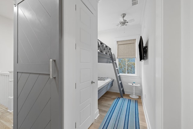 bathroom with crown molding, visible vents, a ceiling fan, wood finished floors, and baseboards