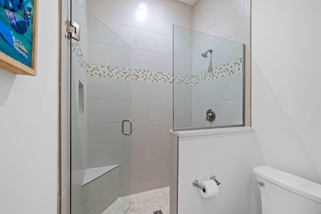 bathroom featuring a walk in shower and toilet