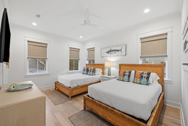 bedroom with ornamental molding, visible vents, baseboards, and wood finished floors