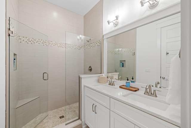 full bath with double vanity, a stall shower, and a sink