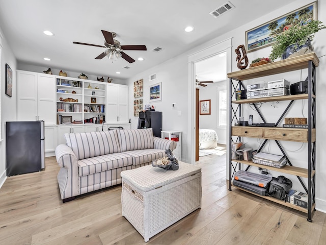 living room with light wood-type flooring, visible vents, a ceiling fan, and recessed lighting