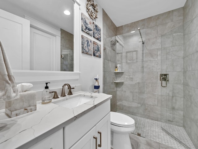 bathroom with a stall shower, vanity, and toilet