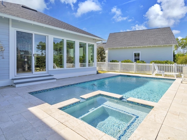 view of swimming pool with a pool with connected hot tub, fence, and a patio