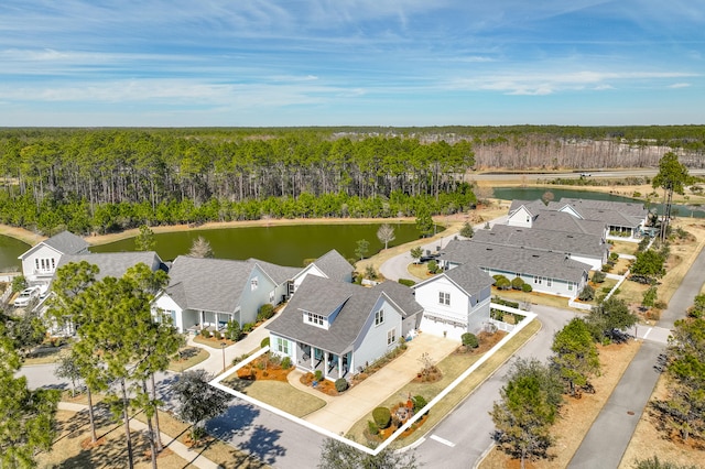 aerial view featuring a forest view, a water view, and a residential view