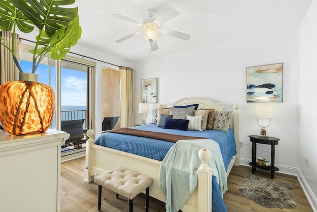 bedroom with access to outside, ceiling fan, baseboards, and wood finished floors