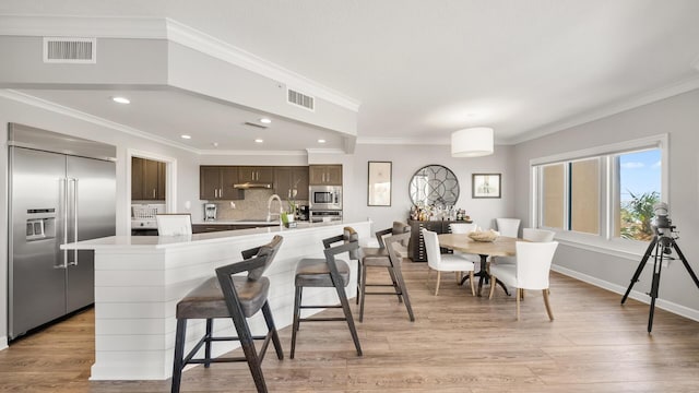 kitchen featuring light countertops, a kitchen island, visible vents, and built in appliances