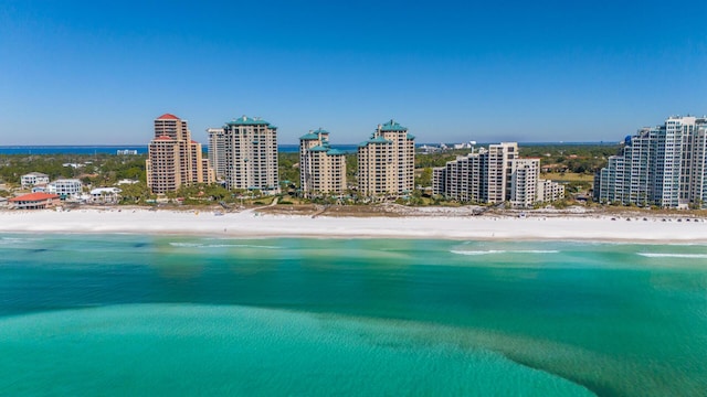 aerial view with a city view, a water view, and a beach view