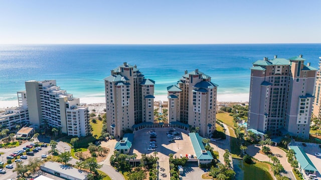 drone / aerial view featuring a water view, a beach view, and a city view