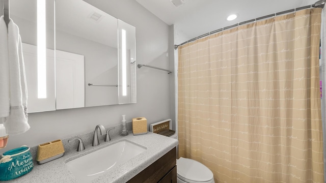 bathroom featuring toilet, visible vents, and vanity