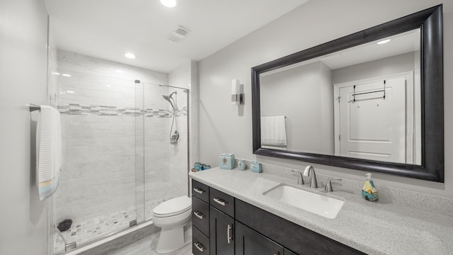 full bathroom featuring recessed lighting, toilet, vanity, and a shower stall