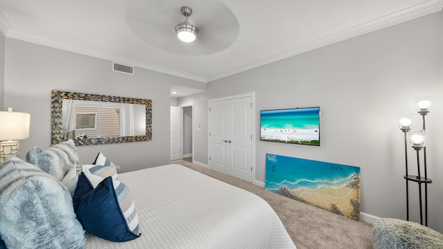 carpeted bedroom featuring baseboards, visible vents, ceiling fan, ornamental molding, and a closet