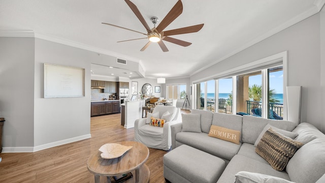 living room with visible vents, ornamental molding, ceiling fan, light wood-type flooring, and baseboards