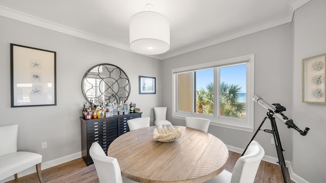 dining area with ornamental molding, wood finished floors, and baseboards