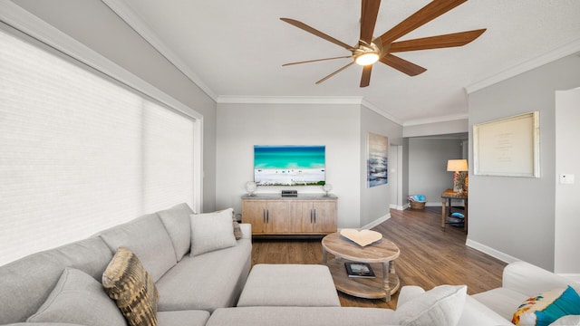 living area with a ceiling fan, baseboards, wood finished floors, and ornamental molding