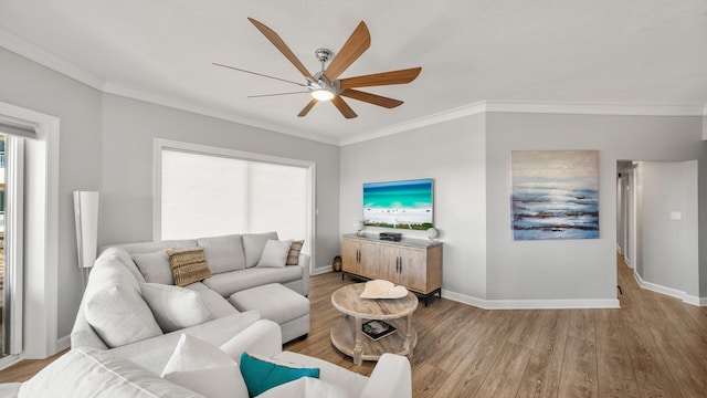 living room featuring light wood-style floors, crown molding, and baseboards