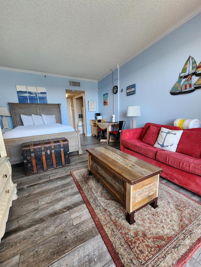 living area featuring a textured ceiling, wood finished floors, visible vents, and crown molding