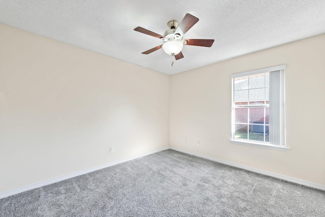 spare room featuring carpet floors, ceiling fan, baseboards, and a textured ceiling