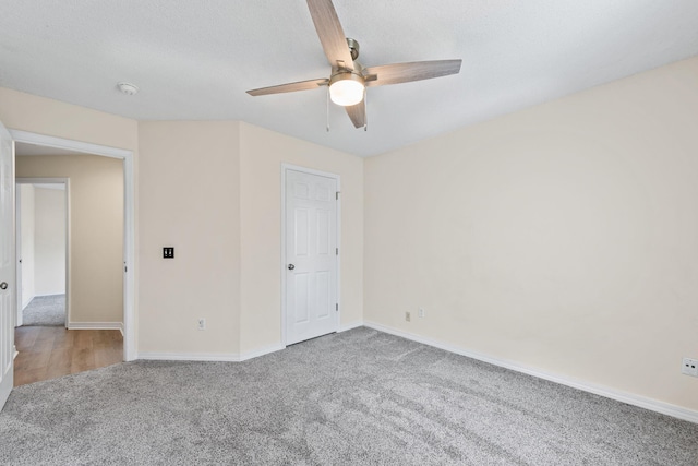 unfurnished bedroom with carpet floors, ceiling fan, a textured ceiling, and baseboards