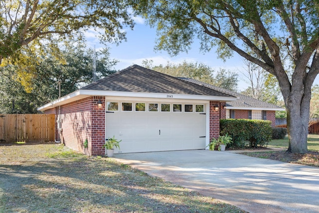 view of front of home with an attached garage, a shingled roof, fence, and brick siding