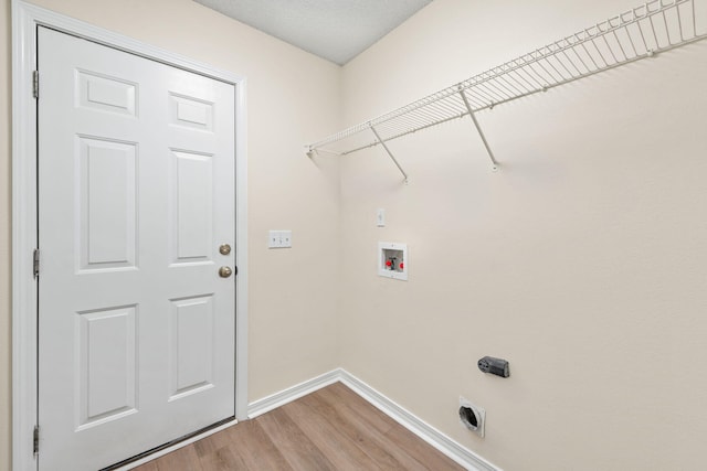 laundry area featuring hookup for an electric dryer, laundry area, washer hookup, baseboards, and light wood-style floors